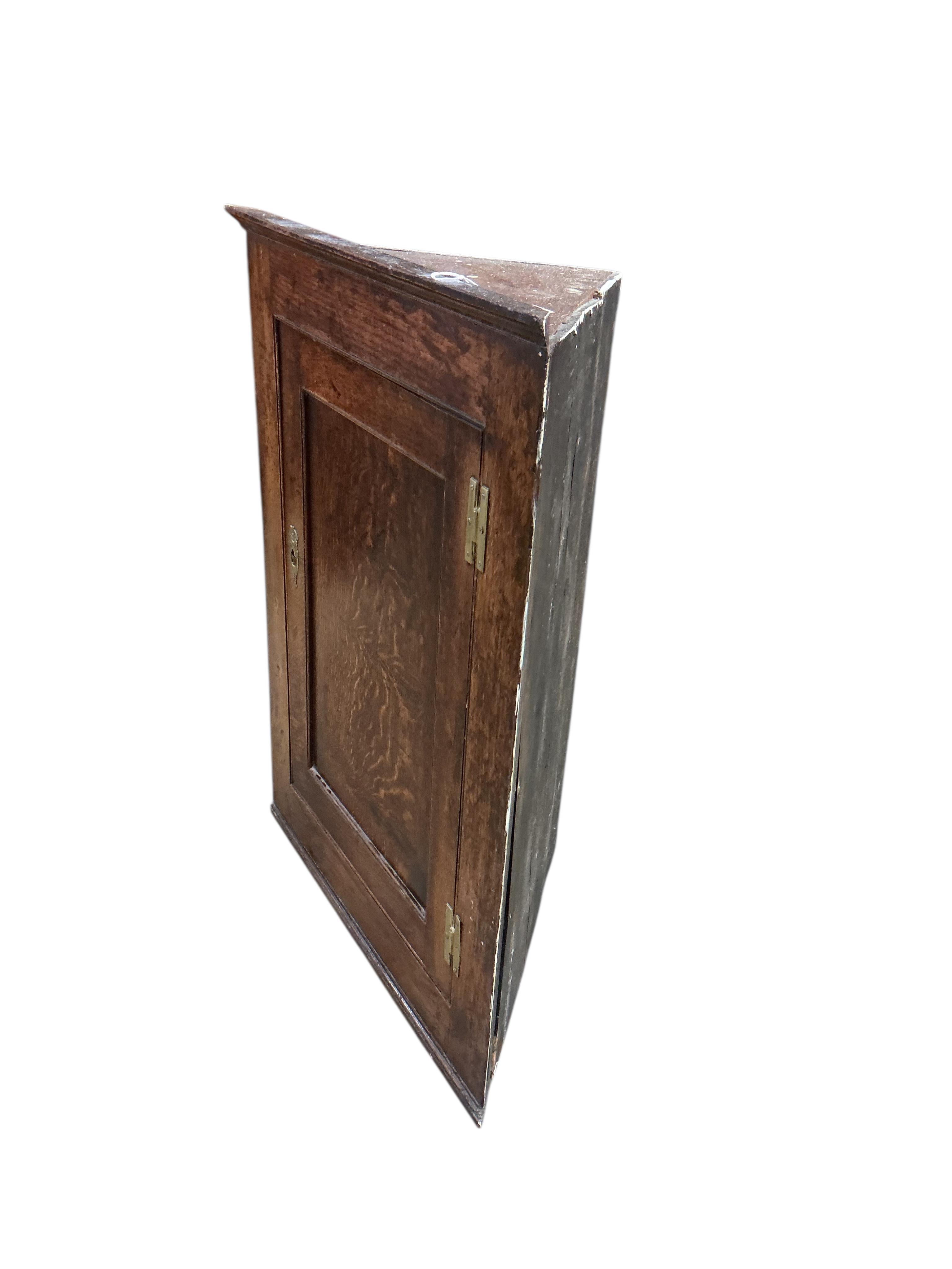 A George III oak hanging corner cabinet, width 63cm, depth 33cm, height 85cm